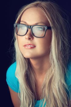 Blonde girl wearing glasses and looking aside 