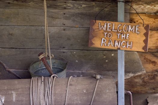 A sign reading "Welcome to the Ranch" hanging in a well house