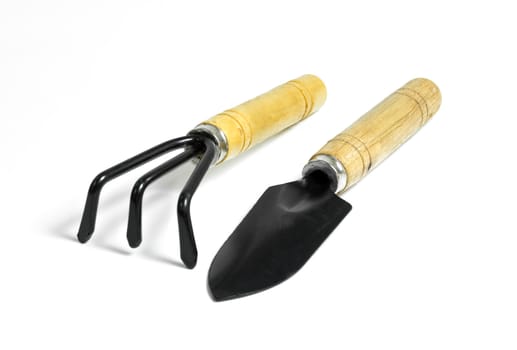 Steel rake and shovel  with a wooden handle on white background