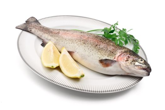 plate with rainbow trout, lemon, and parsley over white background