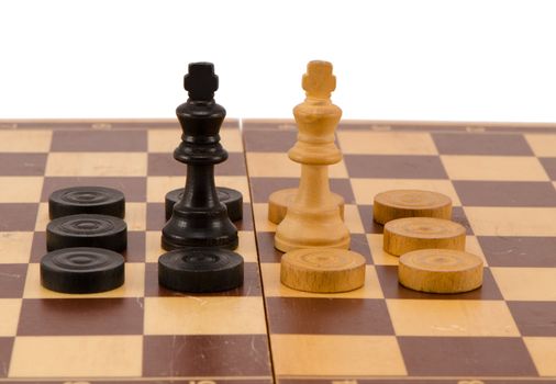 enemy chess queens stand in front surrounded by checkers on wooden board isolated on white.
