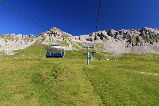 summer landscape of Alpine pasture with chairlift