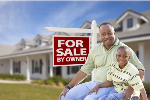 African American Father and Son In Front of For Sale By Owner Real Estate Sign and House.