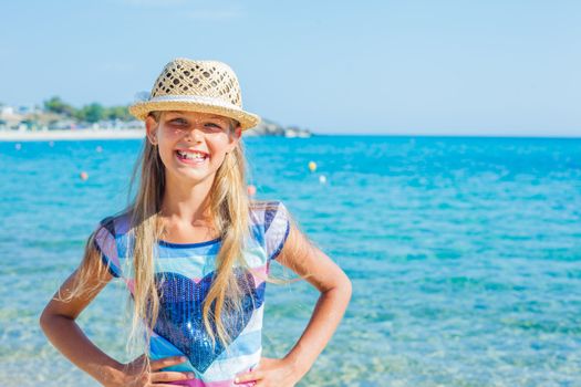 Cutie girl in hat and sun glasses on the beach