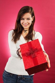 Photo of a beautiful young brunette female holding a wrapped christmas gift.