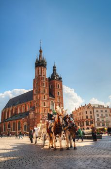 KRAKOW, POLAND - OCTOBER 11: Old market square with horses on October 11, 2012 in Krakow. It's a principal urban space located at the center of the city and – at roughly 40,000 sq. m – it is the largest medieval town square in Europe.