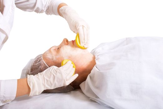 Beautician makes skin treatment woman in spa salon.