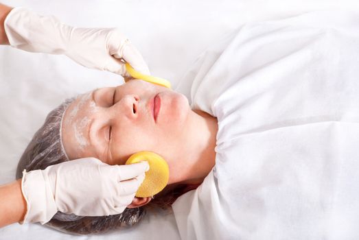 Beautician makes skin treatment woman in spa salon.