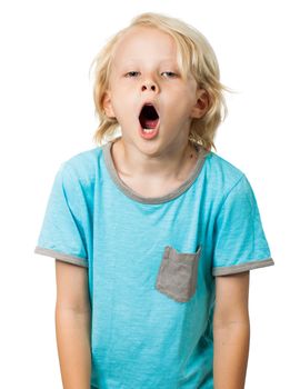 A very tired and bored young boy yawning and looking at camera. Isolated on white.
