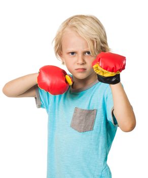 A serious and determined young boy wearing boxing gloves and looking at the camera. Isolated on white.