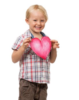 A very cute little boy smiling and holding a love heart for Valentine's day. Isolated on white.