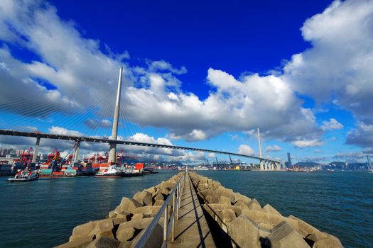 Port warehouse with containers and industrial cargoes , view under bridge on water break at day