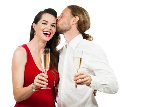 A man giving a woman a kiss on the cheek while having some champagne. Isolated on white.