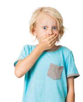 A shocked frightened young boy covering his mouth with his hand and staring wide eyed at the camera. Isolated on white.