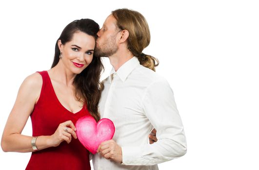 A beautiful couple in love holding a red love heart. Isolated on white.