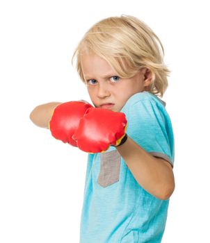 A scared and angry young boy wearing boxing gloves. Isolated on white.