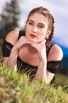 Romantic Girl with Pigtails on a meadow in the mountains
