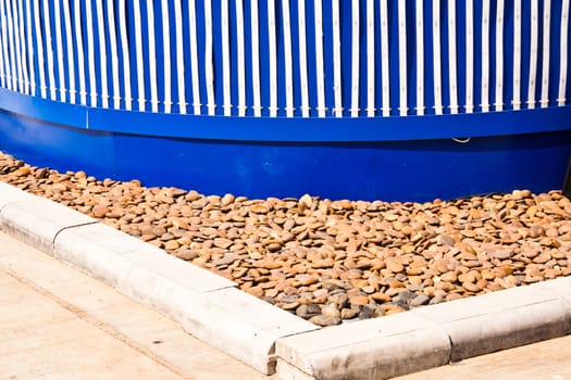 Building on the corner. The ground below the building is decorated with small stones.