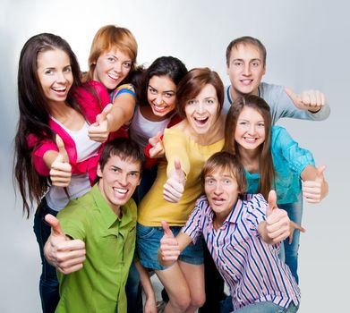 group of casual happy people smiling and shows fingers at the camera