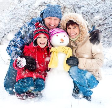 Happy smiling family with snowman winter portrait