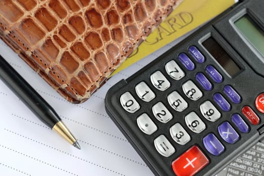 pen, calculator and purse on paper