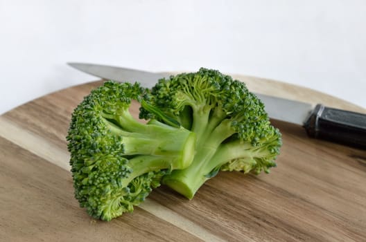 Broccoli vegetable with knife on wooden cutting