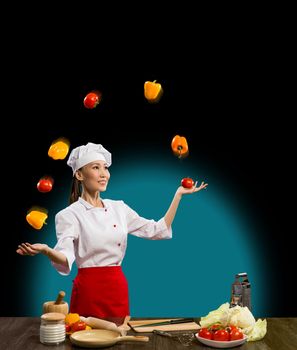 Asian woman chef juggling with vegetables, cooking skills