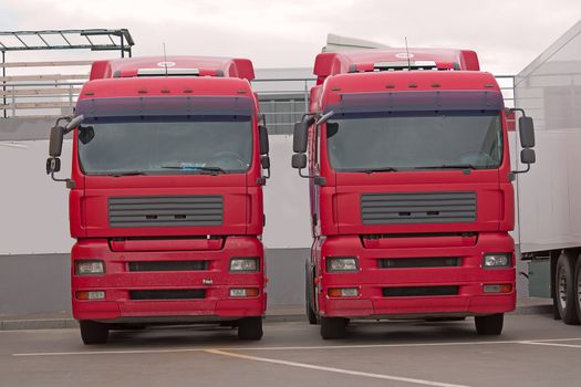 New trucks in  row in parking lot on background sky.