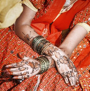 Hands of a young Indian woman adorned with traditional bangles and mehndi. Mehandi, also known as henna is a temporary form of skin decoration in India.