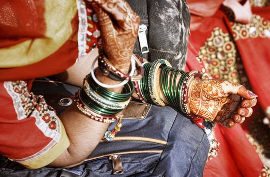 Hands of a young Indian woman adorned with traditional bangles and mehndi. Mehandi, also known as henna is a temporary form of skin decoration in India.