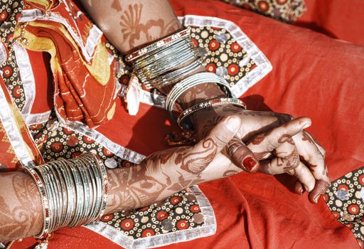 Hands of a young Indian woman adorned with traditional bangles and mehndi. Mehandi, also known as henna is a temporary form of skin decoration in India.
