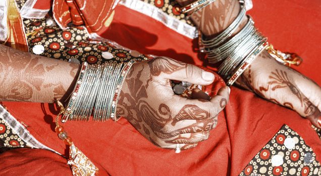 Hands of a young Indian woman adorned with traditional bangles and mehndi. Mehandi, also known as henna is a temporary form of skin decoration in India.