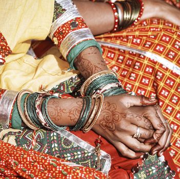 Hands of a young Indian woman adorned with traditional bangles and mehndi. Mehandi, also known as henna is a temporary form of skin decoration in India.