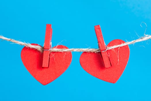 Two heart on clothesline with clothespins, blue background