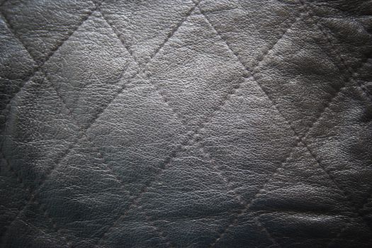 leather texture colose-up with linear stiches. Part of a leather jacket.