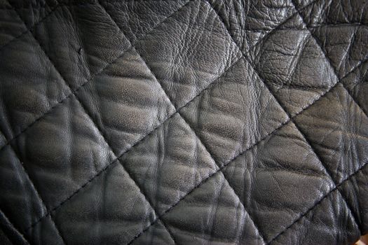 leather texture colose-up with linear stiches. Part of a leather jacket.