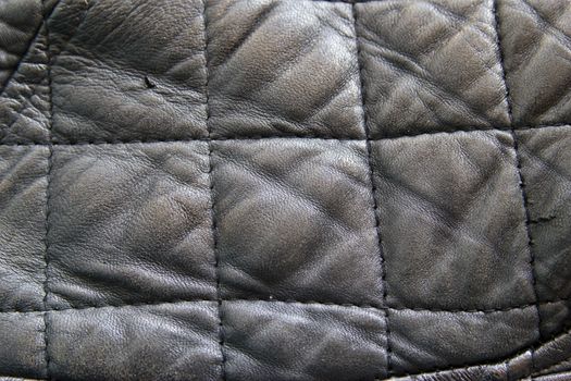 leather texture colose-up with linear stiches. Part of a leather jacket.