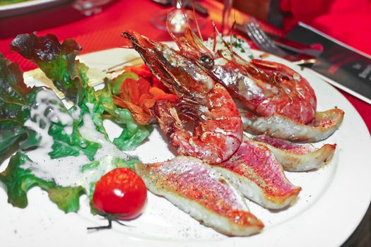 Dish of shrimp and grilled fish in a restaurant