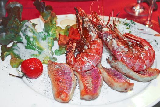 Dish of shrimp and grilled fish in a restaurant