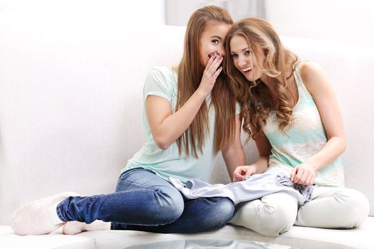 Two young women whispering