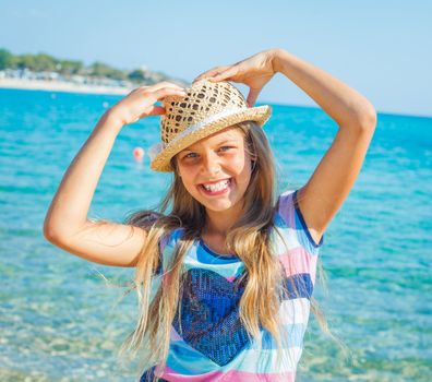 Cute girl in hat on the beach