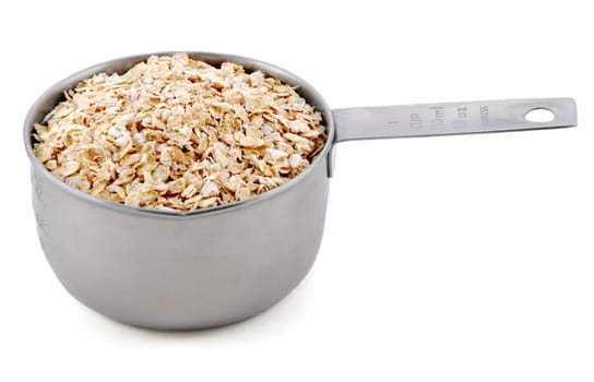 Rolled oats presented in an American metal cup measure, isolated on a white background