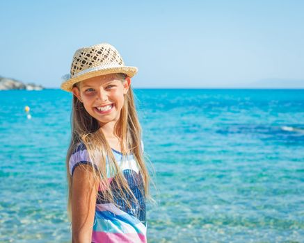 Cute girl in hat on the beach