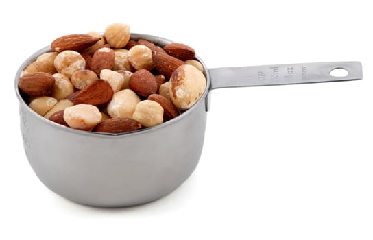 Mixed nuts - almonds, hazelnuts and brazil nuts - presented in an American metal cup measure, isolated on a white background