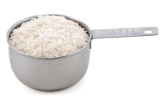 White long grain rice presented in an American metal cup measure, isolated on a white background