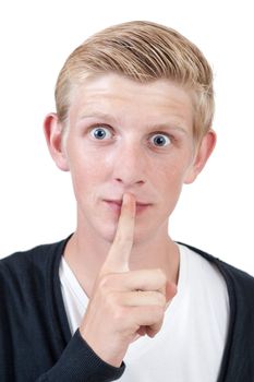 young blond man showing silence gesture, finger over mouth - on white background