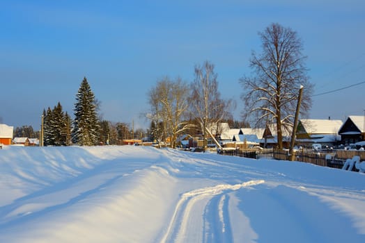 snow-covered village with a triangular roof on the road
