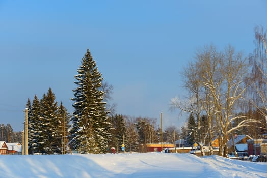 snow-covered village with a triangular roof on the road