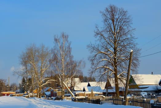 snow-covered village with a triangular roof on the road