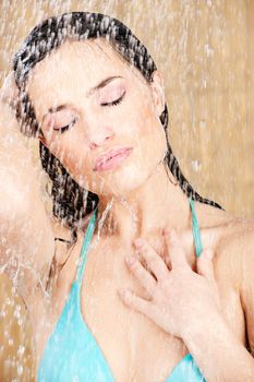 Pretty sensual woman having a shower in tropical environment